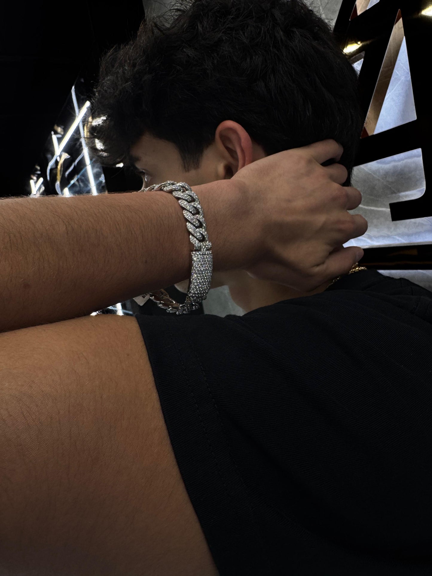 Male model wearing a diamond Miami Cuban bracelet on wrist, styled with a casual luxury outfit to highlight the bracelet’s bold and elegant look