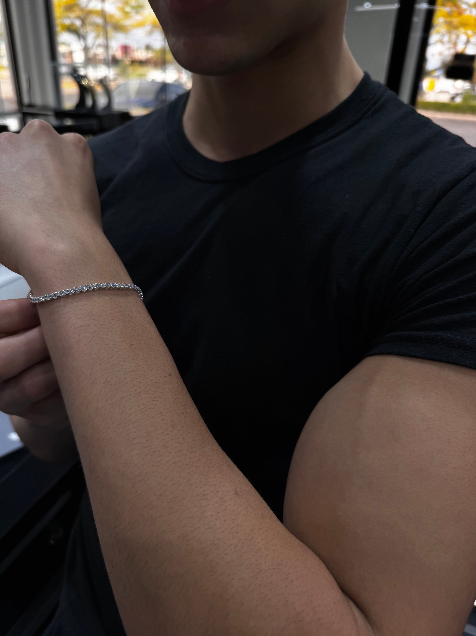 Male model wearing .925 sterling silver lab diamond tennis bracelet styled with casual luxury