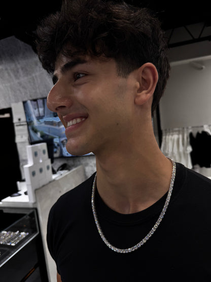 Male model wearing solid gold lab diamond tennis chain with 50 pointer diamonds styled for luxury