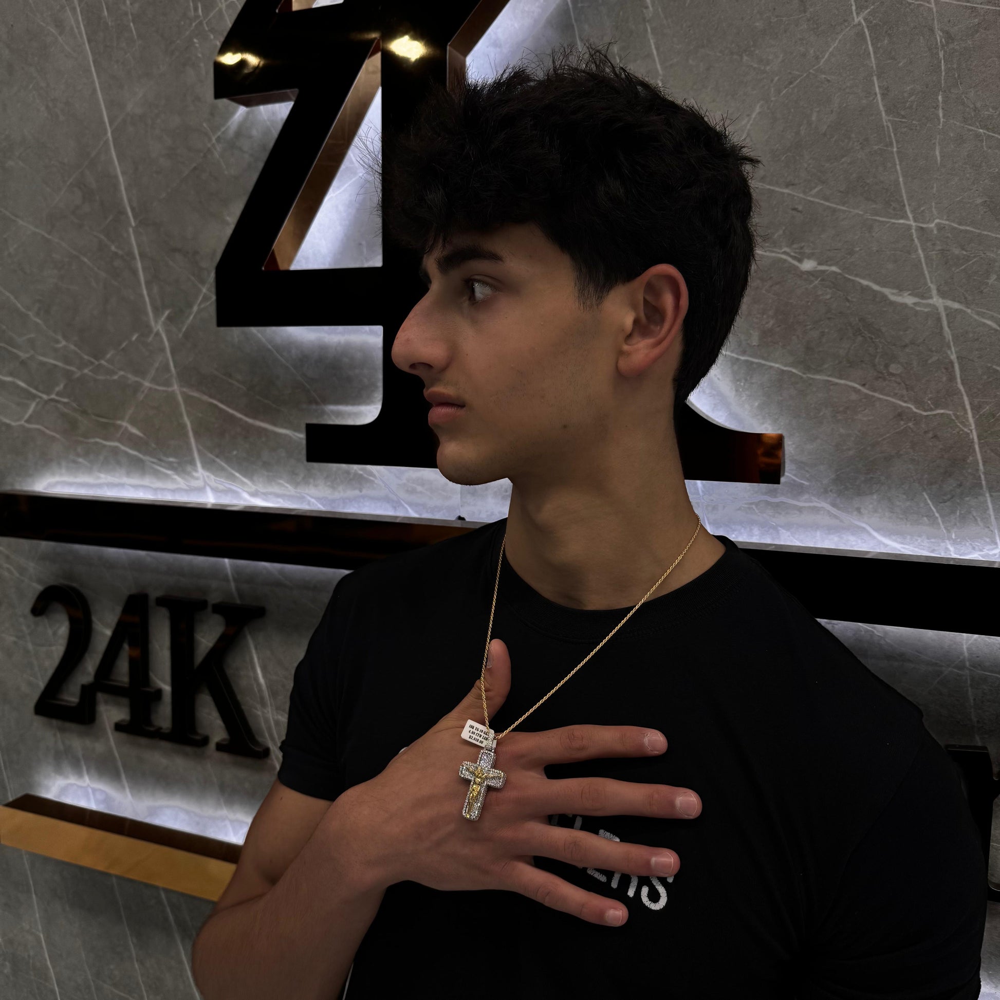 “Male model wearing an invisible set diamond cross pendant on a gold chain, showcasing elegant, seamless diamond placement.”

