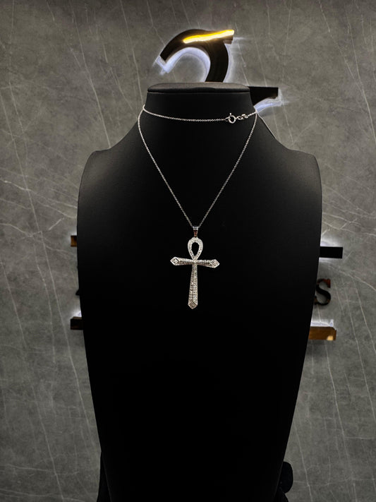 Sterling silver chain with a cross pendant laid flat against a clean background, showcasing the elegant craftsmanship and subtle luxury of the design.