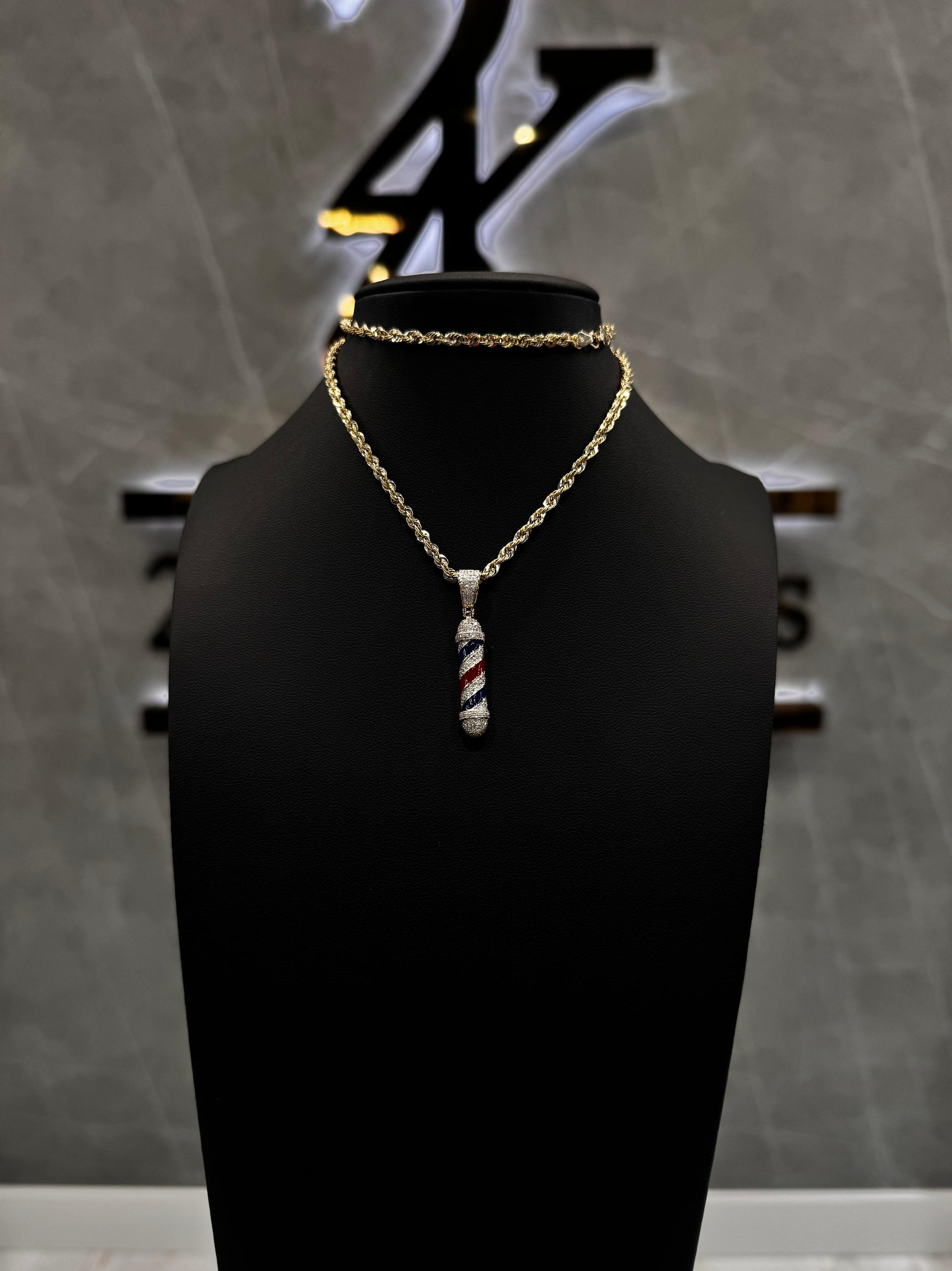 "Diamond barber pole pendant in white gold, featuring natural diamonds and red, white, and blue enamel detailing in a polished, vertical design."