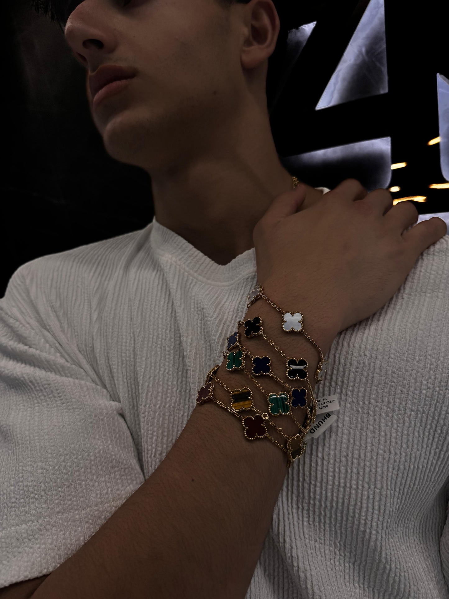 “Male model wearing a Van Cleef & Arpels bracelet on his wrist, styled with a sharp outfit to highlight the unisex sophistication and timeless appeal of the piece.”