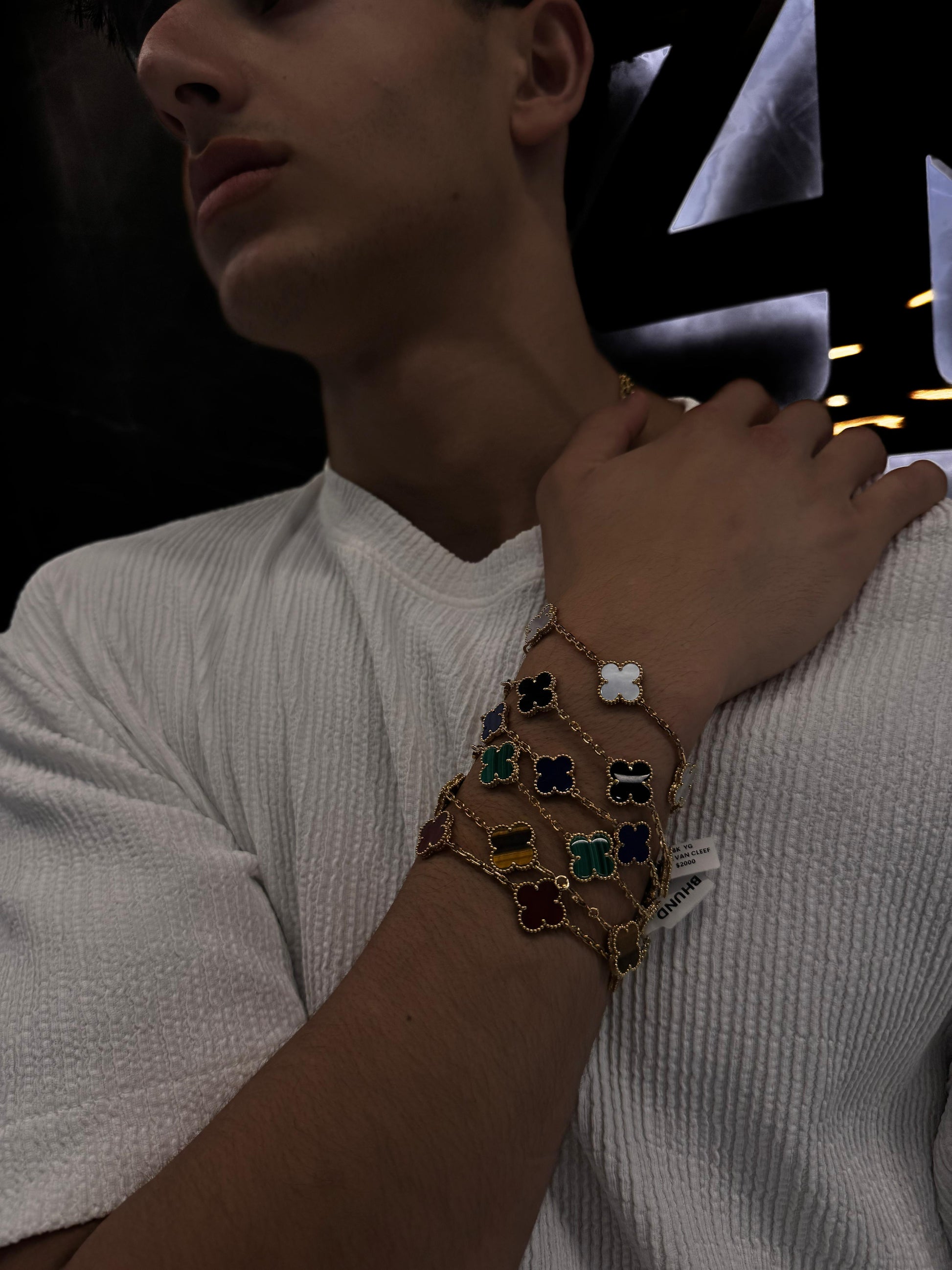 “Male model wearing a Van Cleef & Arpels bracelet on his wrist, styled with a sharp outfit to highlight the unisex sophistication and timeless appeal of the piece.”