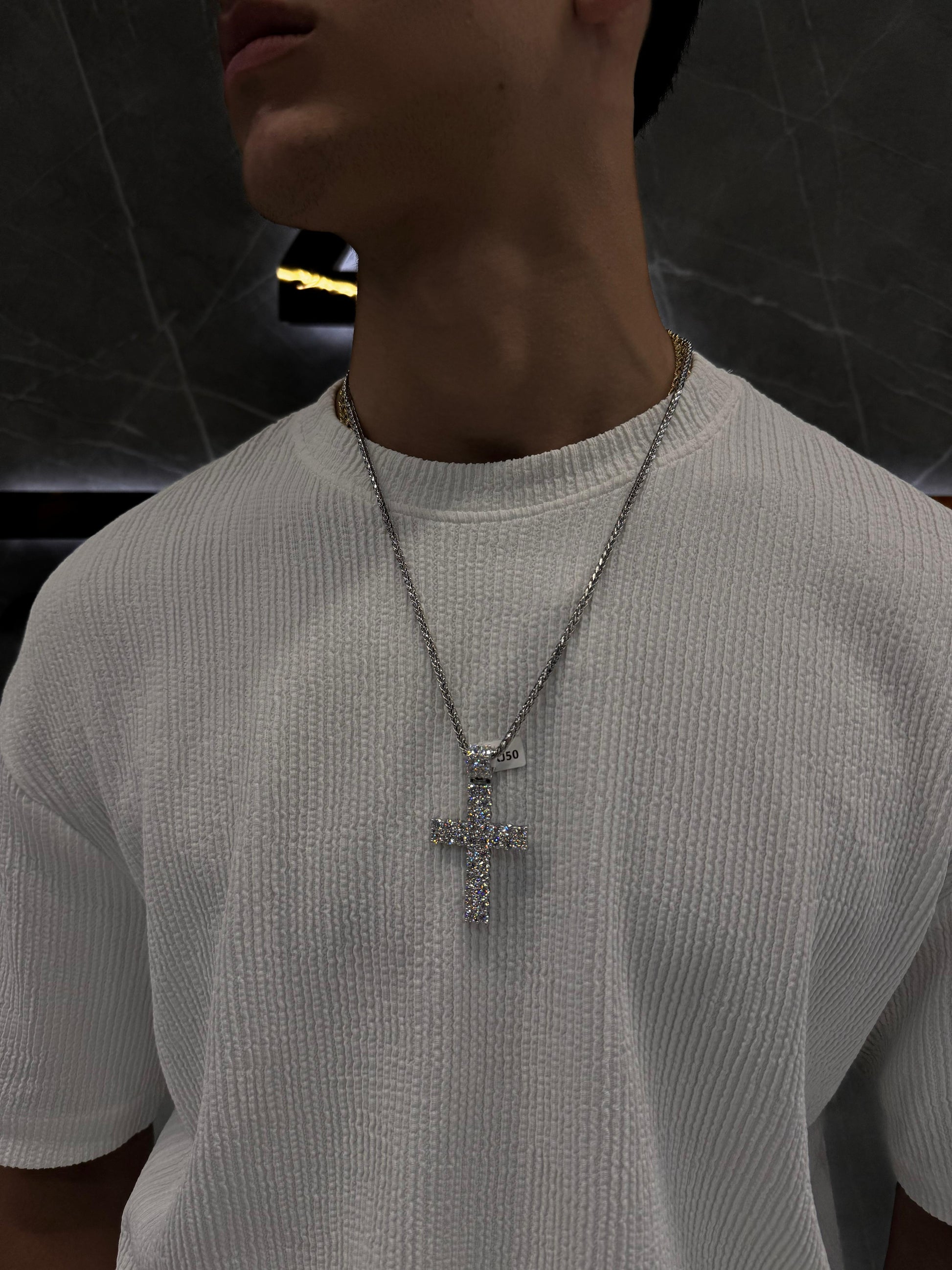 "Male model wearing a double-layered diamond cross pendant on a gold rope chain, styled over a black shirt — showcasing luxury streetwear with a bold, elegant aesthetic."